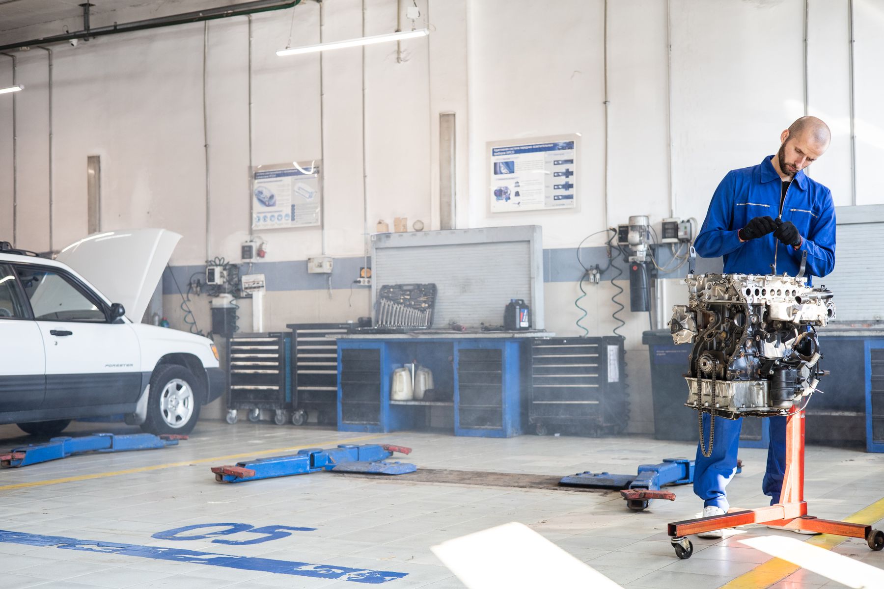Mechanic working on an engine in a bright workshop